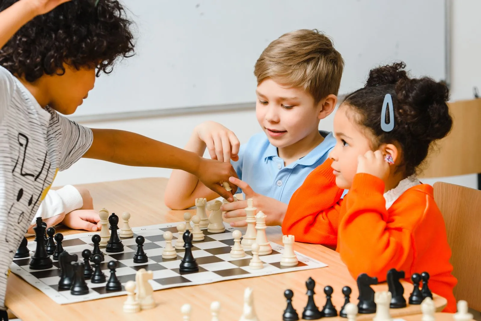 Niños jugando ajedrez en una mesa